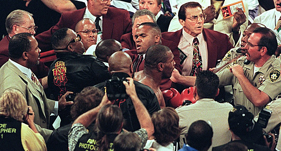 Boxer Mike Tyson (uprostřed) je odváděn policí poté, co svému soupeři Evanderu...