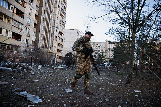 Voják ukrajinské armády prochází mezi domy v Kyjev�. (17. b�ezna 2022)