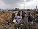Mrtvá tla jsou ukládána do masového hrobu na pedmstí Mariupolu (9. bezna...