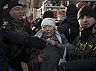 Ukrajintí záchranái s obyvatelkou jedné z ostelovaných budov rezidenní...