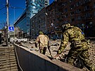 Vojáci jednotek územní obrany kontrolují pokození kyjevské budovy Artem po...