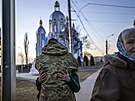 Ukrajinský voják objímá píbuzného prchajícího ped válkou. (16. bezna 2022)