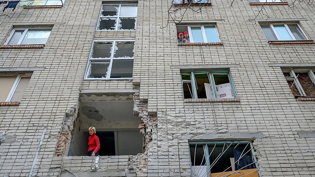 Ukrajinka vyhlíí z poniené budovy, která byla zasaena ruským minometem v...