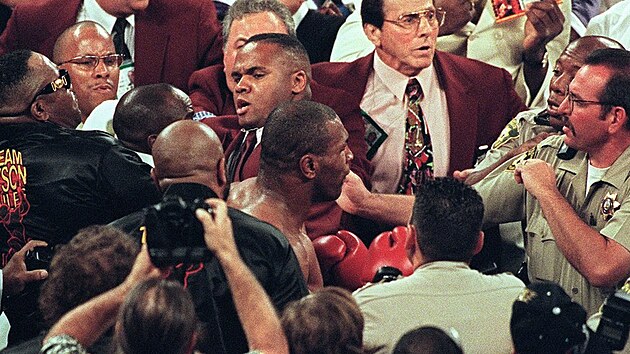 Boxer Mike Tyson (uprostřed) je odváděn policí poté, co svému soupeři Evanderu Holyfieldovi ukousl při vzájemném souboji 28. června 1997 kus ucha.