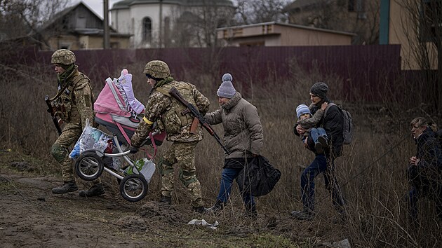 Ukrajint vojci pomhaj prchajc rodin pekroit eku na pedmst Kyjeva. (5. bezna 2022)