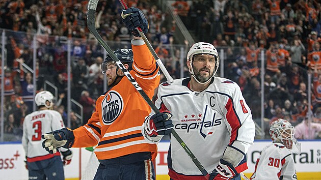 Brad Malone (v oranovm) z Edmonton Oilers slav gl v zpase s Washington Capitals, vpravo Alexandr Ovekin.