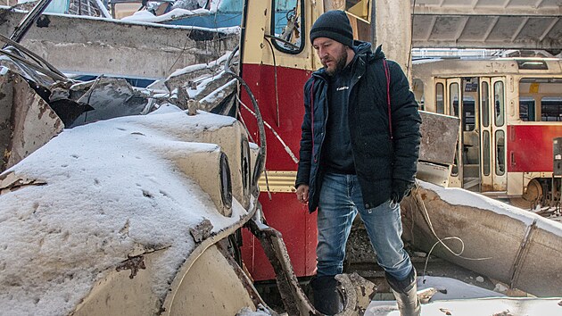 Tramvaje ve vozovn v ukrajinskm Charkov pokodila zcen konstrukce budovy po ostelovn ruskmi silami. (12. bezna 2022)