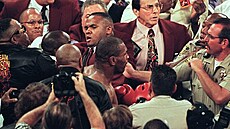 Boxer Mike Tyson (uprosted) je odvádn policí poté, co svému soupei Evanderu...