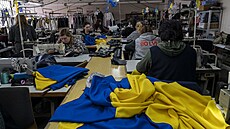 Dobrovolníci ve Lvov ijí ukrajinské vlajky a lékárniky. (14. bezna 2022)