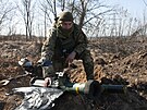 Ukrajinský voják drí pozice v zákopu u msta CHarkov. (24. bezna 2022)