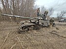 Ukrajintí vojáci si prohlíejí zniený ruský tank. (28. bezna 2022)