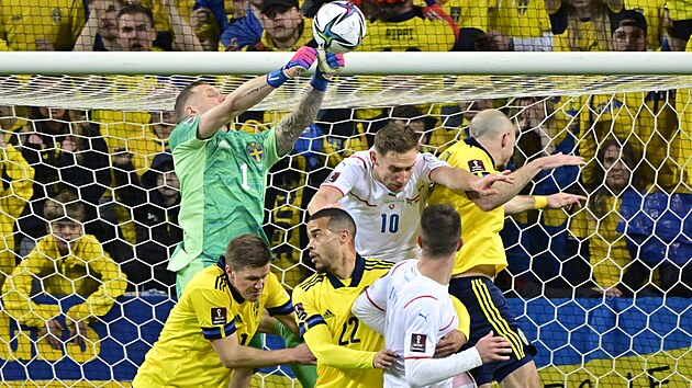 Švédský gólman Robin Olsen boxuje balon po centru z kopačky českého fotbalisty. | na serveru Lidovky.cz | aktuální zprávy