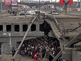 Lidé se ukrývají pod mostem pi pokusu utéct z Kyjeva pes eku Irpi. (5....