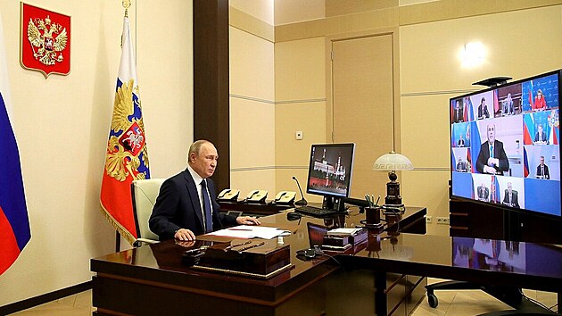 Rusk prezident Vladimir Putin pi virtuln porad bezpenostn rady. Ministr obrany Sergej ojgu je na obrazovce vlevo nahoe. (24. bezna 2022)