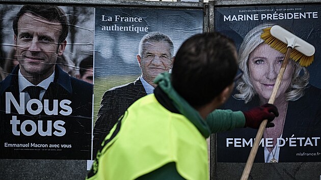 Vylepovn plakt kandidt ped prezidentskmi volbami ve Francii. Zleva Emmanuel Macron, Jean Lassalle a Marine Le Penov (28. bezna 2022)