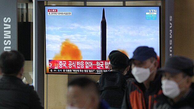 Lid� na n�dra�� v jihokorejsk�m Soulu sleduj� televizi, kter� ukazuje sn�mek odp�len� severokorejsk� rakety. (24. b�ezna 2022)