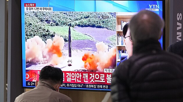 Lid na ndra v jihokorejskm Soulu sleduj televizi, kter ukazuje snmek odplen severokorejsk rakety. (24. bezna 2022)
