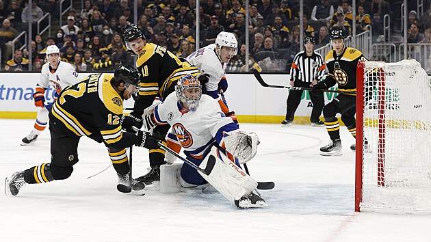 Brank New York Islanders Semjon Varlamov inkasuje z hole bostonskho Craiga Smithe.