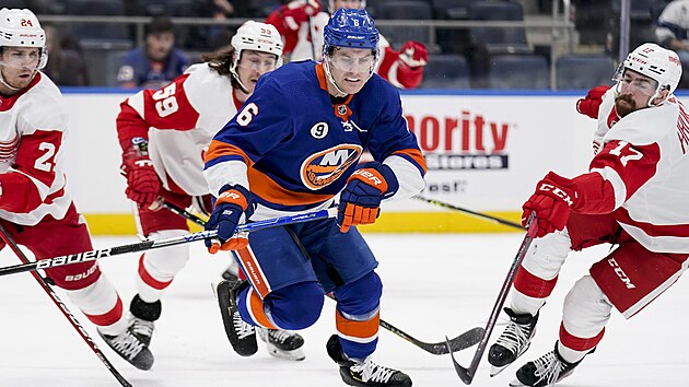 Filip Hronek (vpravo) a Pius Suter (vlevo) z Detroitu se sna zastavit prnik Ryana Pulocka z New York Islanders.