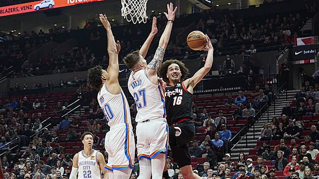 V�t Krej�� (uprost�ed) a Olivier Sarr z Oklahoma City Thunder zastavuj� naj�d�j�c�ho C. J. Ellebyho z Portland Trail Blazers.