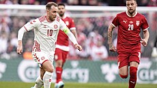 Dánský fotbalista Christian Eriksen vede mí v utkání proti Srbsku.