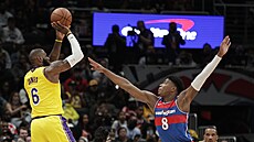 LeBron James z Los Angeles Lakers pi stelb, brání ho Rui Hachimura z...