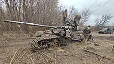 Ukrajintí vojáci si prohlíejí zniený ruský tank. (28. bezna 2022)