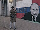 Rutí uprchlíci si v Blehrad fotí nástnnou malbu Vladimira Putina. (17....