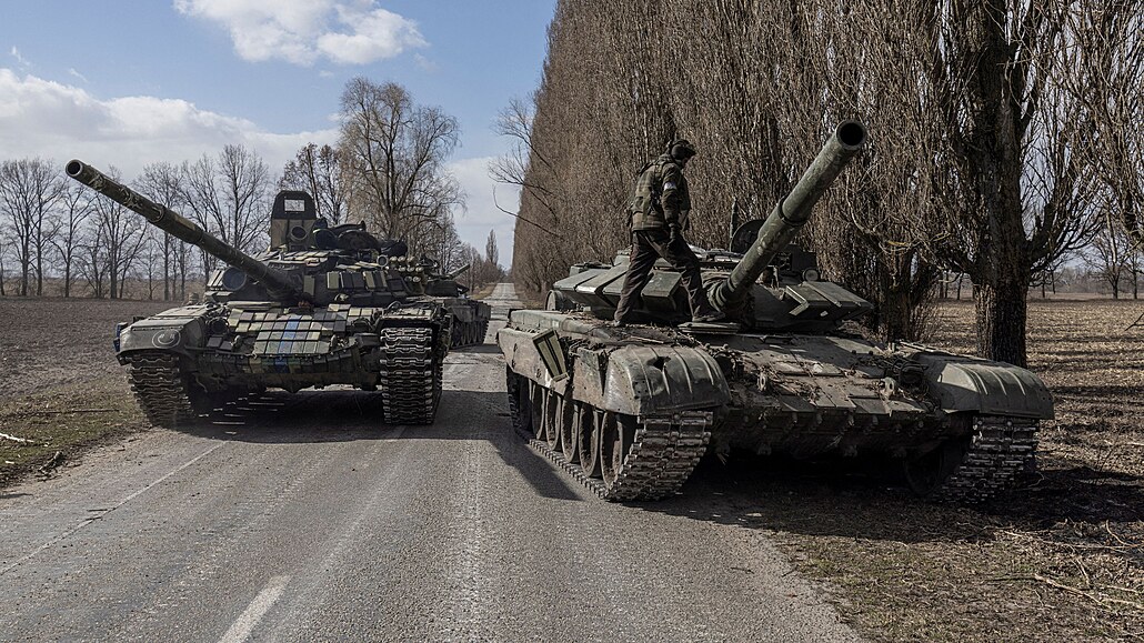 Ukrajinský voják stojí na vrcholu ruského tanku po bojích s ruskými jednotkami...