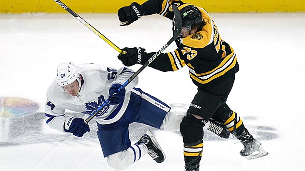 David Kmpf (vlevo) z Toronto Maple Leafs pad na led, srazil ho Charlie McAvoy z Boston Bruins.