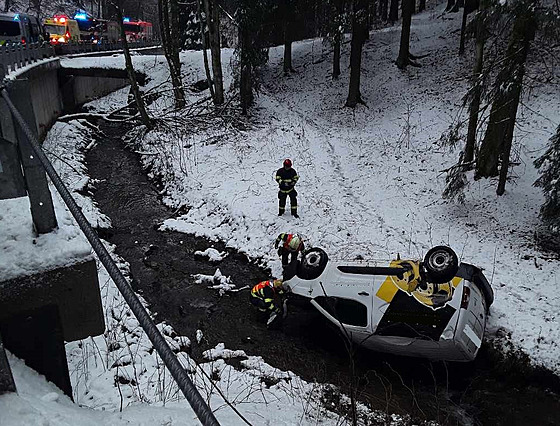 Malá dodávka skonila v potoce pevrácená na stechu.