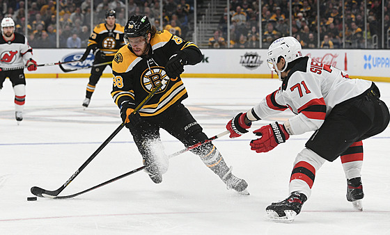 David Pastrák (88) z Boston Bruins vede útok kolem Jonase Siegenthalera (71) z...