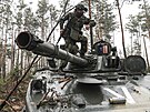 Ukrajintí vojáci prohlíejí ruský tank zabavený v lese v Irpinské oblasti, kde...