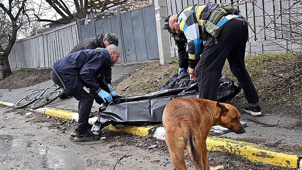 Muži odklízejí mrtvá těla v ukrajinském městě Buča v Kyjevské oblasti. (2....