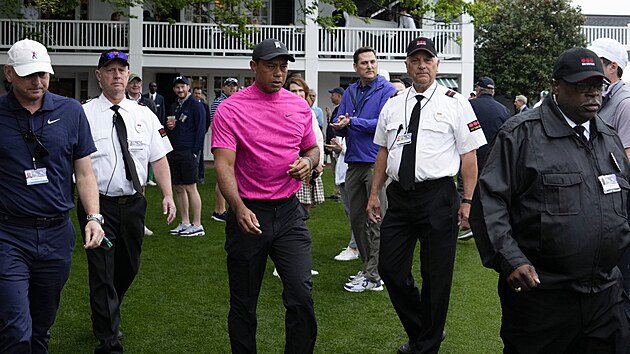 Tiger Woods (uprosted) pichz doprovzen ochrankou na hit v August.