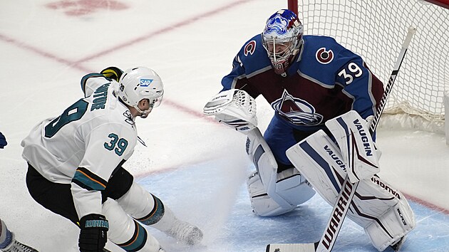 Pavel Francouz v brn Colorado Avalanche, dor na nj Logan Couture ze San Jose Sharks.