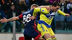 Útočník Dušan Vlahovič z Juventusu (vpravo) si kryje míč před Matteem Lovatem z...