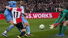 Slávistický brankář Ondřej Kolář startuje po míči před Linssenem z  Feyenoordu...
