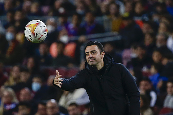 Barcelonský trenér Xavi Hernández podává balon bhem ligového zápasu s Cádizem.