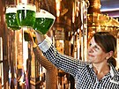 Servírka drí pllitry se zeleným velikononím pivem v restauraci minipivovaru...