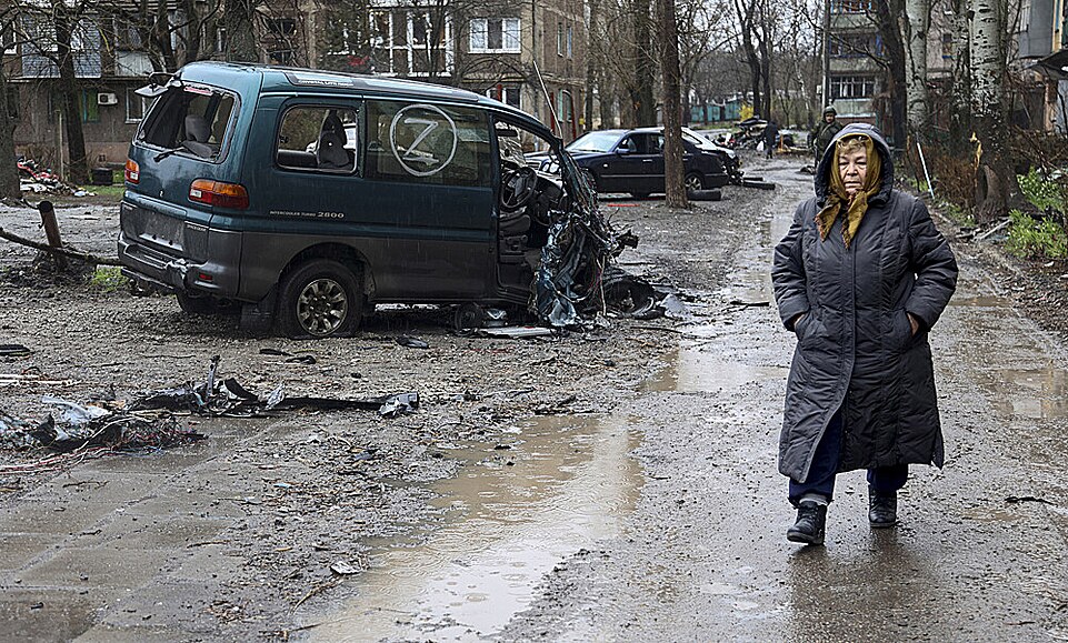 Obyvatelka Mariupolu prochází kolem znieného auta s ruským oznaením Z. (13....