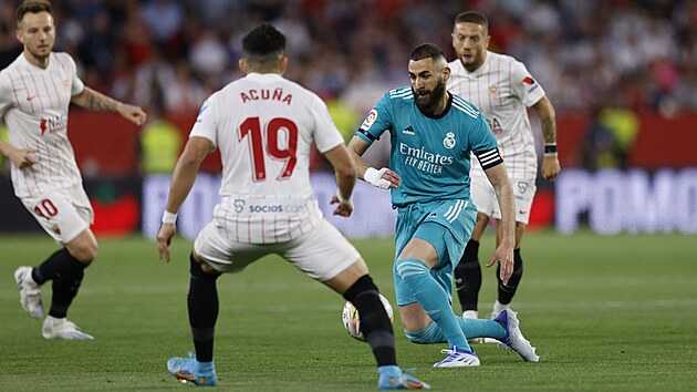 tonk Realu Madrid Karim Benzema (uprosted) se chyst vyhnout Marcosovi Acunovi ze Sevilly