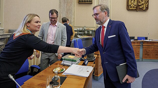 Premir Petr Fiala se zdrav s ministryn obrany Janou ernochovou. (13. dubna 2022)