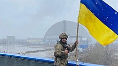 Ukrajinský voják instaluje ukrajinskou státní vlajku v areálu jaderné...