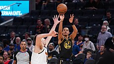 Jordan Poole z Golden State pálí, brání ho Nikola Joki z Denveru.