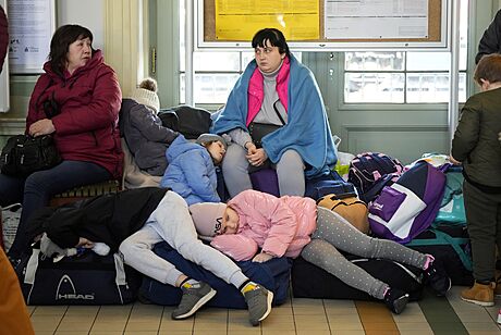 Dti z Ukrajiny spí na zavazadlech na nádraí v Pemyli na jihovýchod Polska....