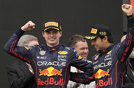 Vítz Max Verstappen slaví s týmovým parákem a druhým v cíli Sergiem Pérezem...