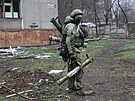 Voják milice Doncké lidové republiky prochází kolem budovy pokozené bhem...