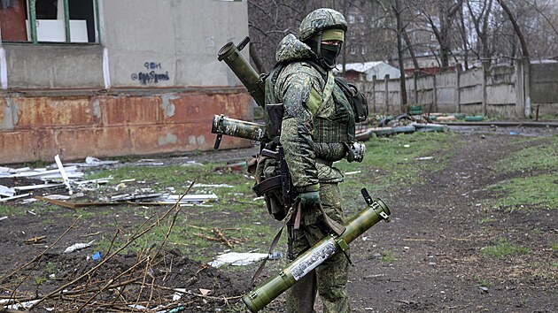 Voják milice Don�cké lidové republiky prochází kolem budovy po�kozené b�hem...