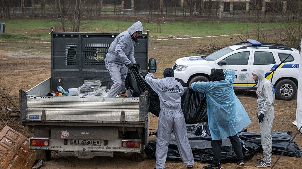 Francouzští a ukrajinští forenzní experti vyzvedávají těla obětí ruské agrese z...